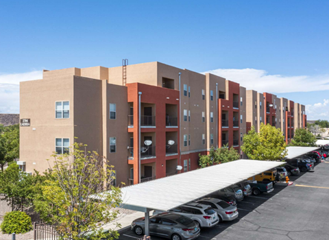 A long building with a parking lot in front.